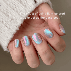 Nails with cat eye gel design held by a person wearing a white textured sleeve.