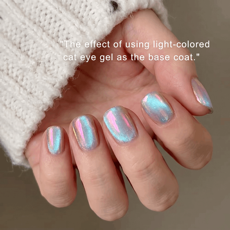 Nails with cat eye gel design held by a person wearing a white textured sleeve.