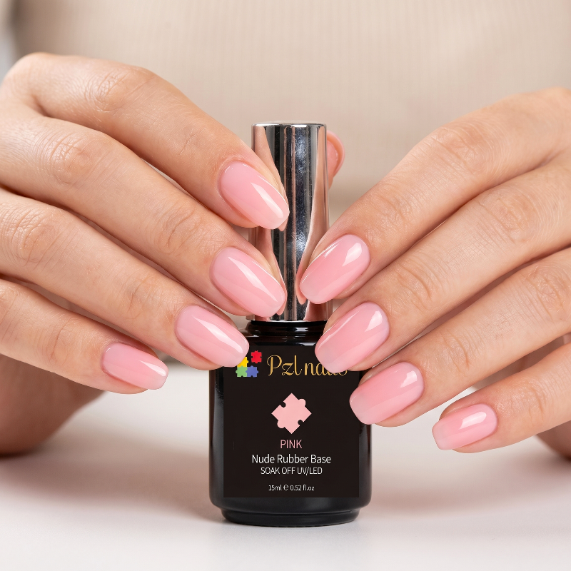 Person holding a bottle of pink nail polish with matching nails against a neutral background