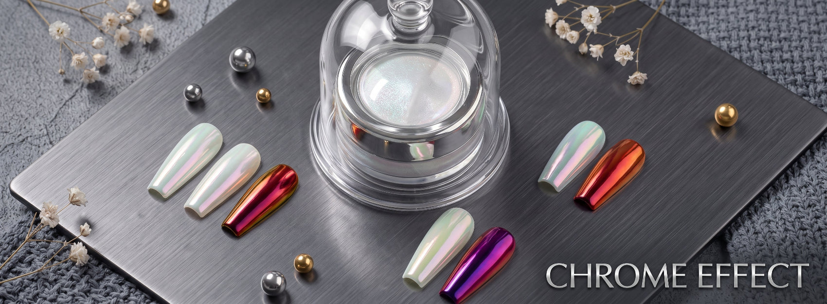 A set of iridescent chrome-effect nail tips displayed on a dark gray metal tray, with a glass dome cover, decorative beads, dried flowers, and the text 'CHROME EFFECT' in the bottom right corner.